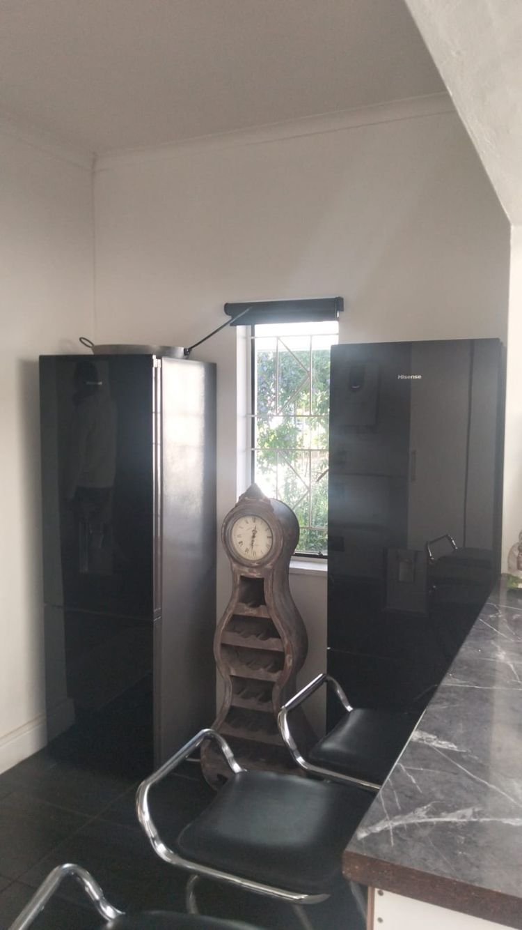 Before: an empty wall with a window, between two fridges